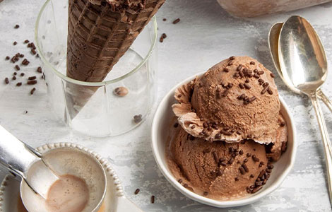Chocolate ice cream scoops in a bowl topped with chocolate sprinkles, 
served with a waffle cone and spoons at Cream Curls Dunfermline 
